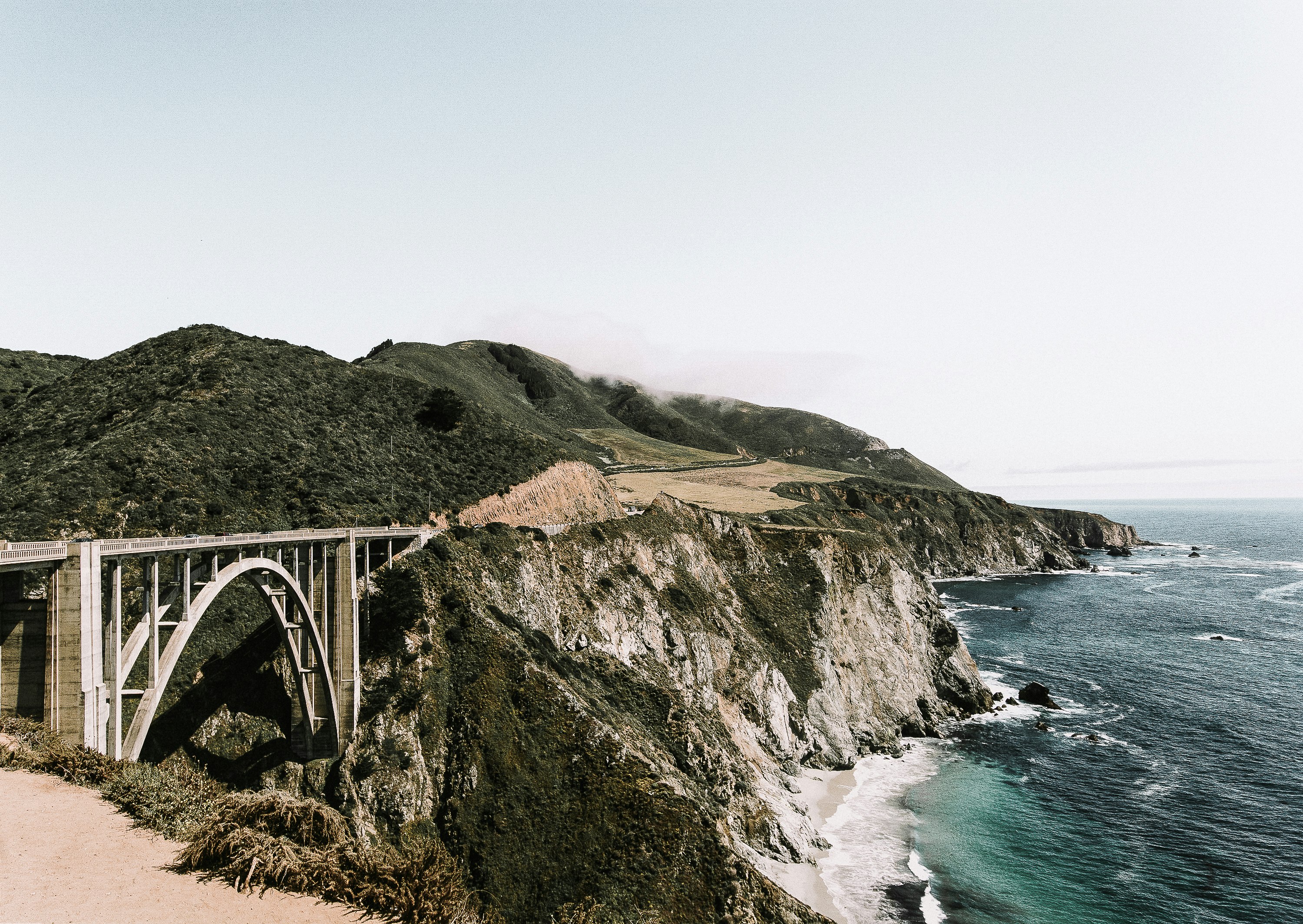 photo of white bridge on mountain